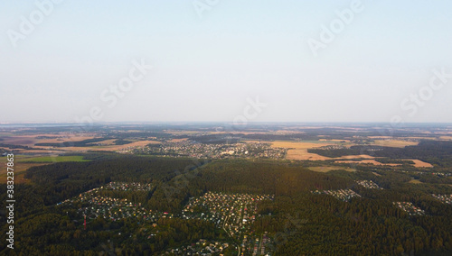Beautiful top view of a forest landscape with green trees near the suburb © Payllik