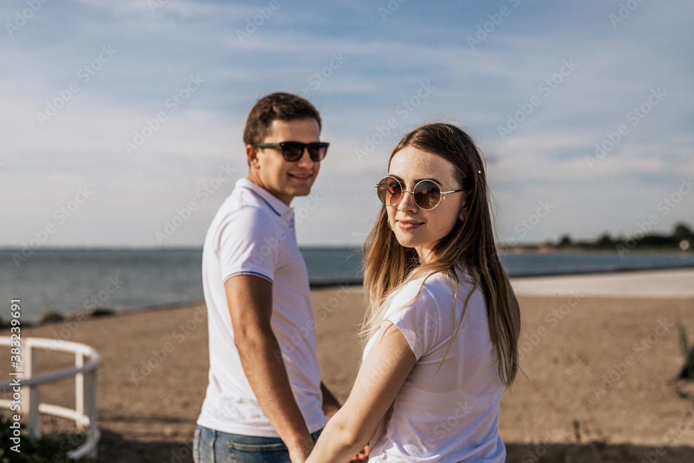 Close up of happy romantic couple hold hands and walk on the beach