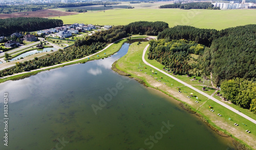 Top view of a beautiful city summer park with a lake and an embankment. 