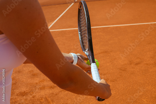 Player's hand with tennis ball preparing to serve