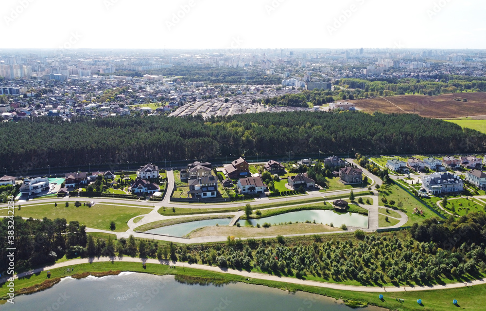 Top view of a beautiful suburb with houses near a park lake