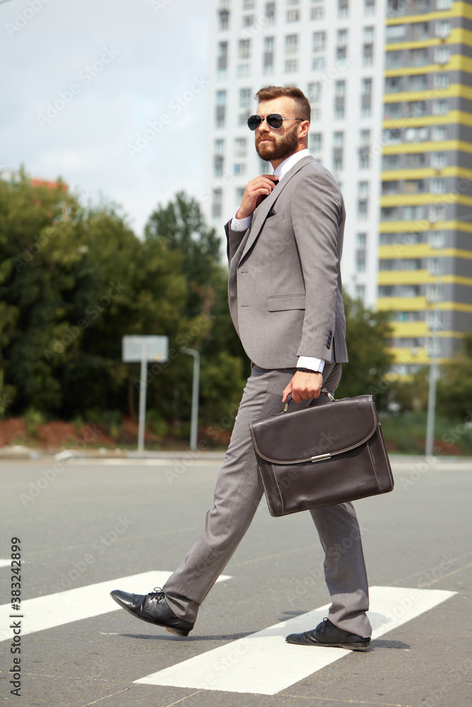 handsome caucasian guy in suit walk, cross the street alone, after work. break time