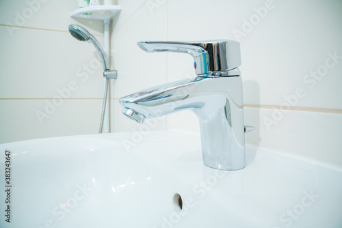 chromed metal faucet for hot and cold water  in a modern bathroom