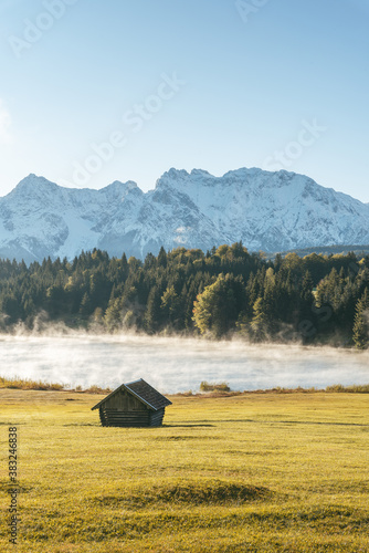 Scenic view of Geroldsee Lake and fog during sunrise with hut in foreground photo