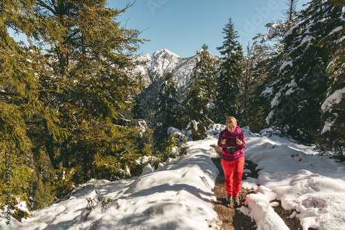 Wanderin im Neuschnee auf dem Wanderweg zur Heimgarten Hütte am Walchensee photo