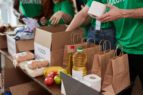 Vászonkép group of diverse people sort through donated food items while volunteering in co