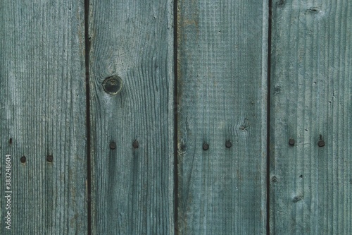 Tablas de madera antiguas de una valla exterior desgastada y rugosa. Primer plano de madera con nudos y dañada por el paso del tiempo.