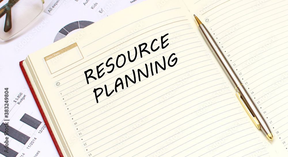 An open diary with text lies on an office desk with financial charts. Business concept.