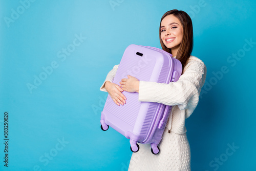 First class vacation. I am ready. Portrait of positive cheerful girl hug her violet baggage cant wait travel abroad wear good look white outfit isolated over blue color background