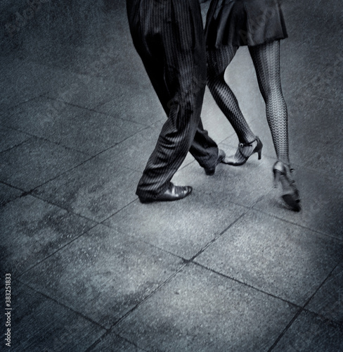 Creative B&W film shot of two tango dancers in the street. Visible grain film grain