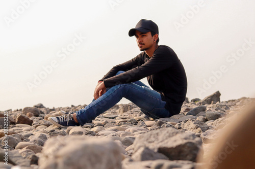 Young indian man standing on rocks