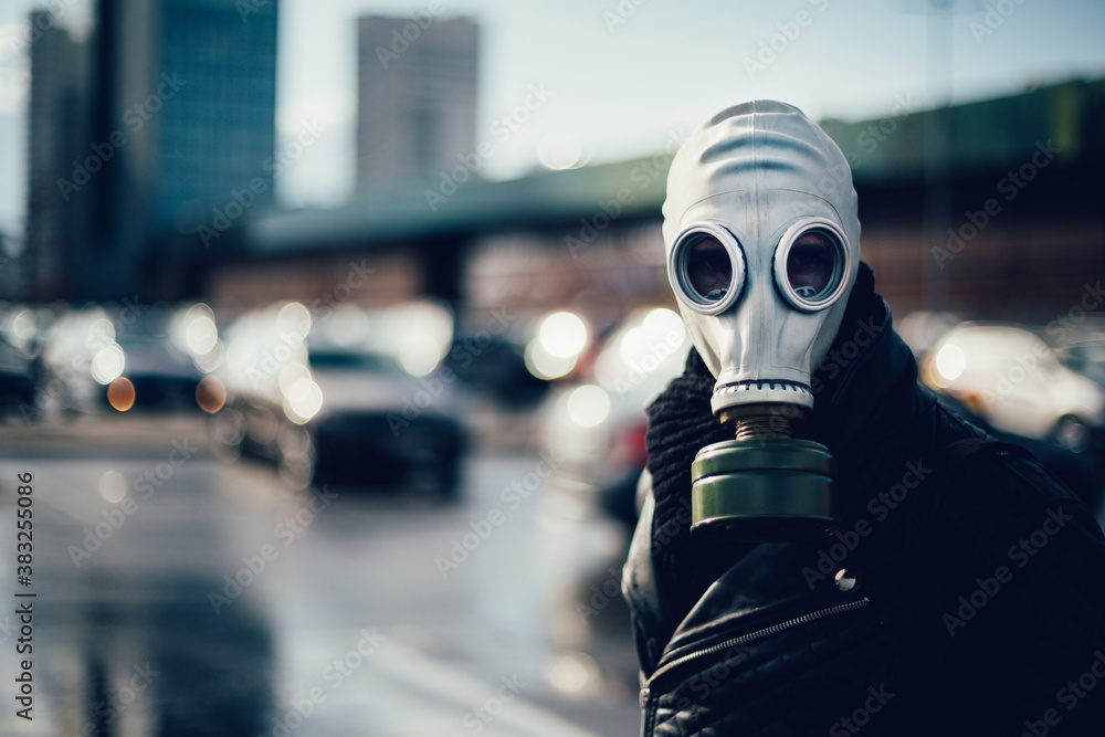 casual young man in a gas mask looking at the camera casual young man in a gas mask looking at the camera