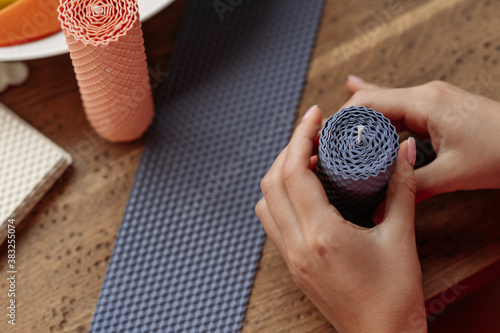 DIY wax candle making process. Woman making decorative wax candle, close-up of hands