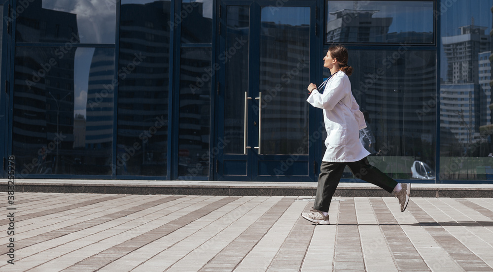 woman doctor runs down a city street.