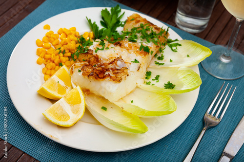 Tasty healthy dinner of baked kingklip fillet served with fresh vegetables, greens and lemon photo