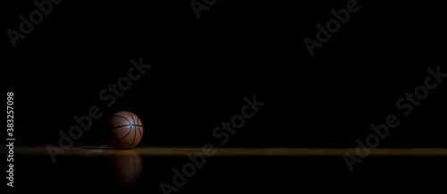 Basketball On Hardwood Court Floor With Spot Lighting. Workout online concept. Long web banner copy space