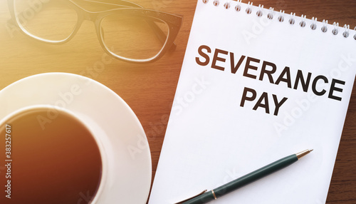 Fototapeta Naklejka Na Ścianę i Meble -  Text, the inscription, the phrase Severance Pay is written in a notebook that lies on a dark table with a cap of coffee and glasses. Business concept.