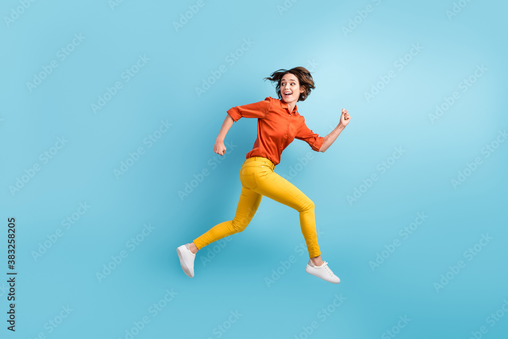 Full size profile photo of attractive funny lady rushing shopping center sale discount runaway want come first early morning wear orange shirt trousers sneakers isolated blue color background