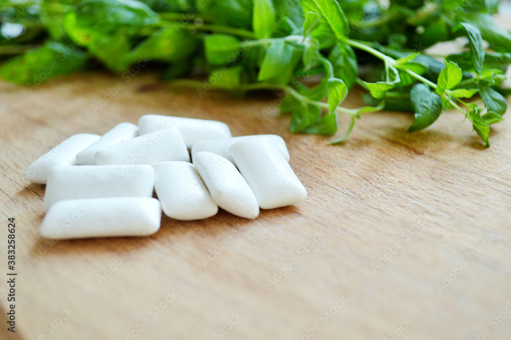 Bunch of fresh mint and gum pads on wooden background Bunch of fresh mint and gum pads on wooden background