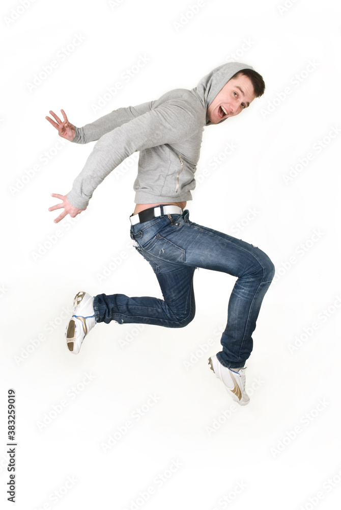 Young man dancing in a gray sweatshirt on a white background