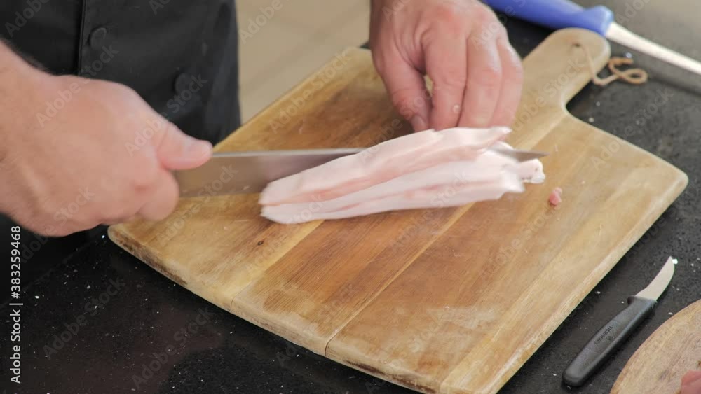 Close-up of cutting pork fat into cubes for cooking. Close-up of cutting pork fat into cubes for cooking.