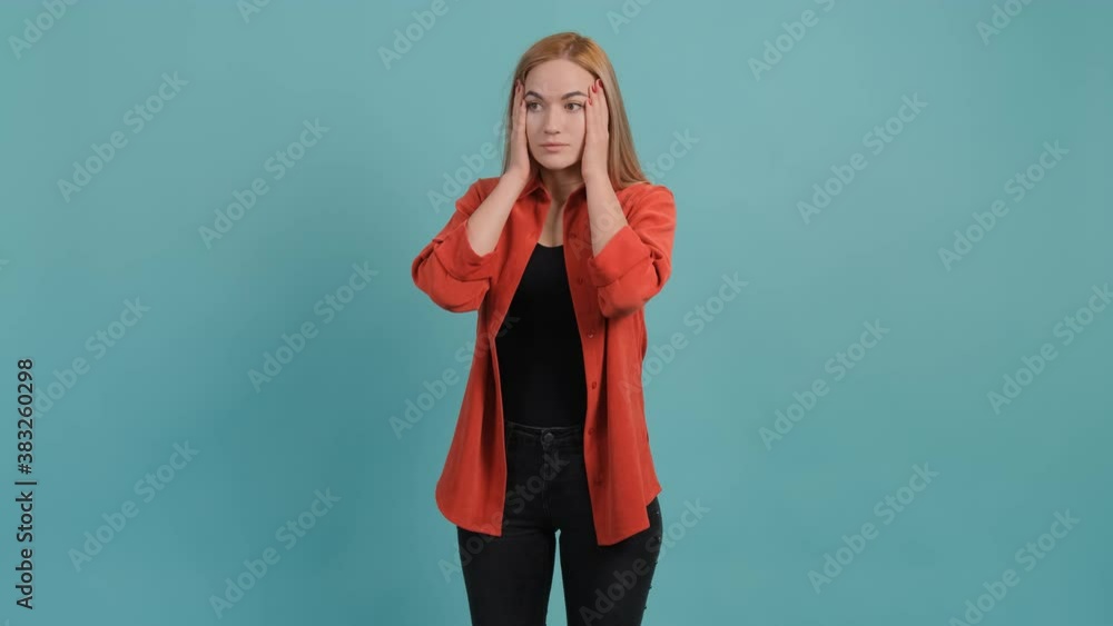 Confused woman holding hands on head over turquoise studio background. Confused woman holding hands on head over turquoise studio background.