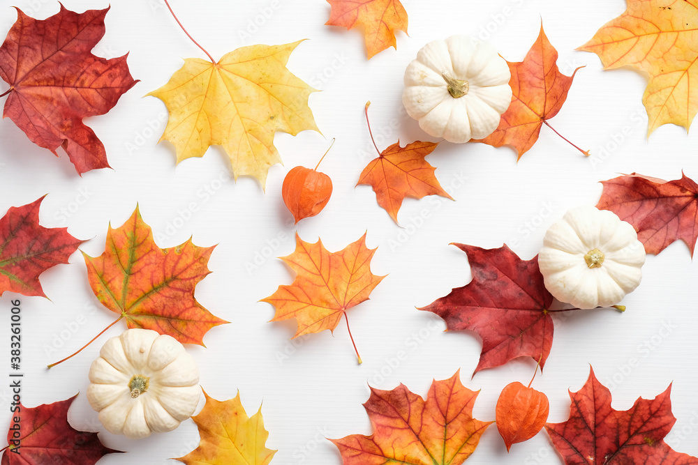 Autumn composition. Colorful maple leaves and pumpkins on white table. Seasonal background. Autumn fall, thanksgiving, harvest concept. Flat lay, top view.