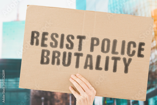 Fényképezés The phrase  Resist police brutality  on a banner in men's hand with blurred European Union flag on the background