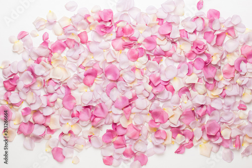 Fototapeta Naklejka Na Ścianę i Meble -  Pink rose flowers petals on white background. Flat lay, top view, copy space.