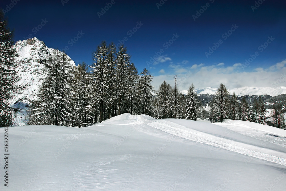 Ski tracks in the snow under the Croda Rossa di Sesto mountain (German: Sextener Rotwand) or Zehner is a mountain in the Sexten Dolomites in South Tyrol, Italy - UNESCO World Heritage Site - obrazy, fototapety, plakaty 