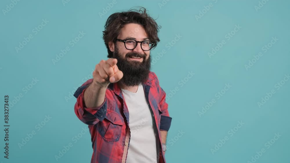 Close up of a smiling handsome bearded man pointing at you over turquoise background. Close up of a smiling handsome bearded man pointing at you over turquoise background.