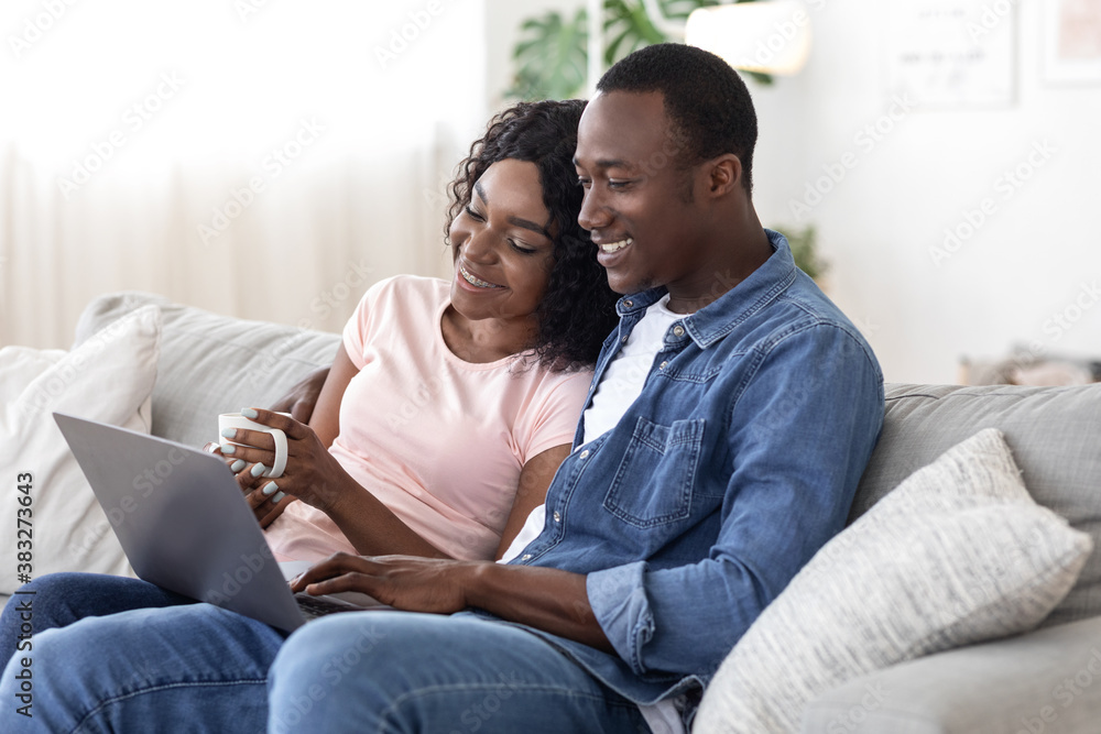 Happy black couple websurfing, using laptop at home Happy black couple websurfing, using laptop at home