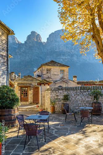 Fototapeta Naklejka Na Ścianę i Meble -  view of traditional architecture  with   stone buildings and background astraka mountain during  fall season in the picturesque village of papigo , zagori Greece