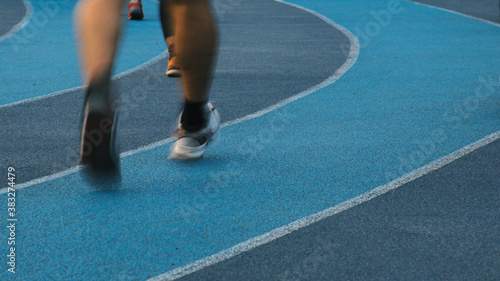 Motion blurred runner's feet on the jogging track