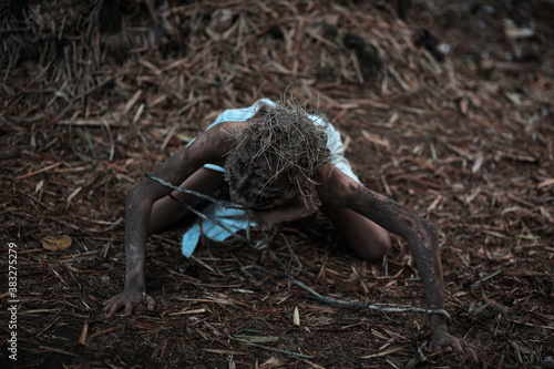 Scary scarecrow crawling in dark forest. Halloween background