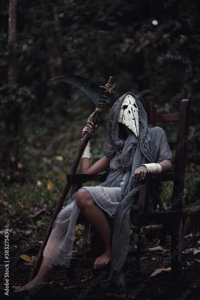 grim reaper holding scythe sitting in the dark forest. Halloween background