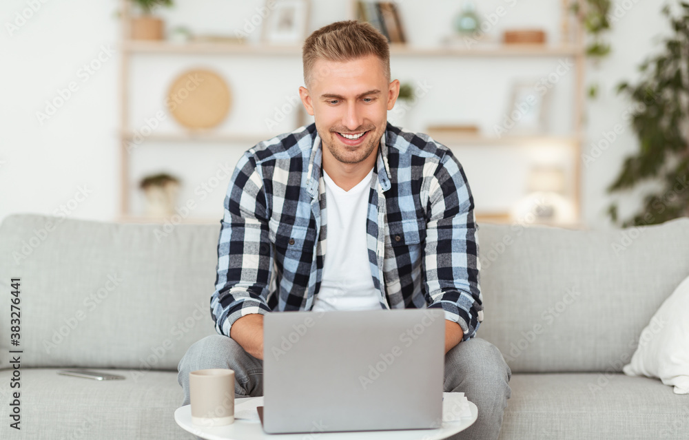 Happy man chatting online on laptop with friend at home Happy man chatting online on laptop with friend at home