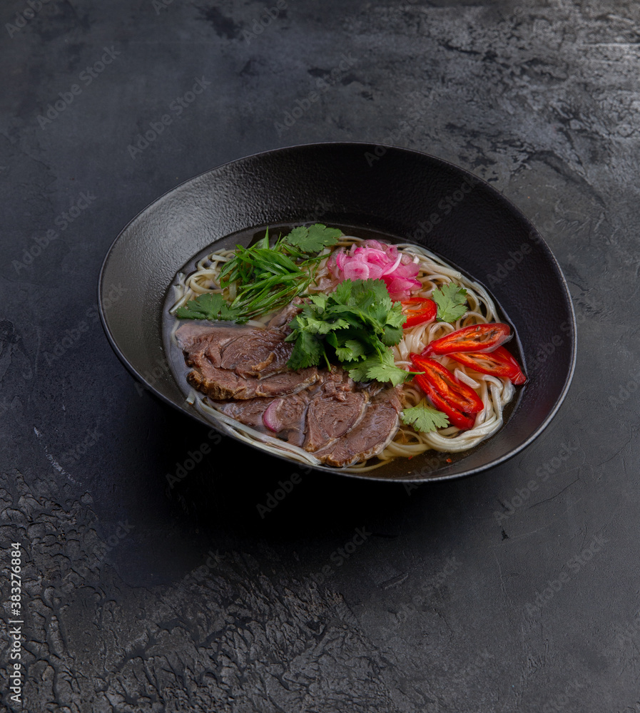 Traditional vietnamese pho bo soup in dark plate Traditional vietnamese pho bo soup in dark plate