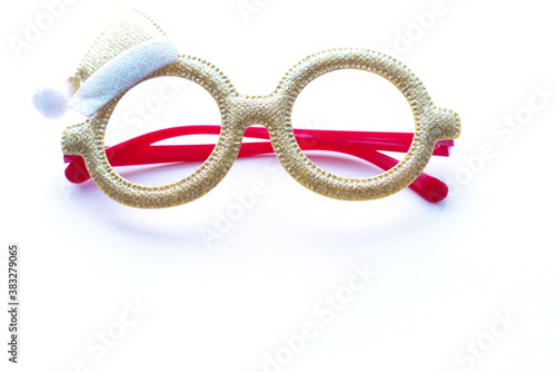 fashion accessory, holiday glasses with sequins and a Christmas hat. Bright, shiny glasses lie on a white surface. Place for text, inscriptions. Leisure, winter, Christmas holidays, new year. Glasses 