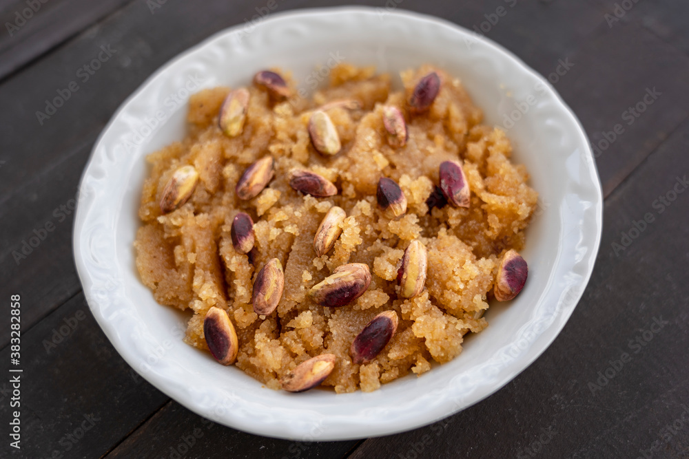 semolina halva. Turkish dessert; irmik helvası with pistachio on wooden background semolina halva. Turkish dessert; irmik helvası with pistachio on wooden background