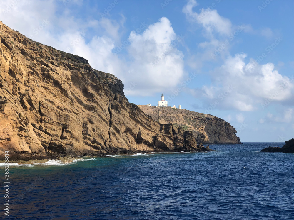 Reserva natural de las Islas Columbretes (Castellón) - faro desde el mar entre las rocas en un día de sol y nubes. Reserva natural de las Islas Columbretes (Castellón) - faro desde el mar entre las rocas en un día de sol y nubes.