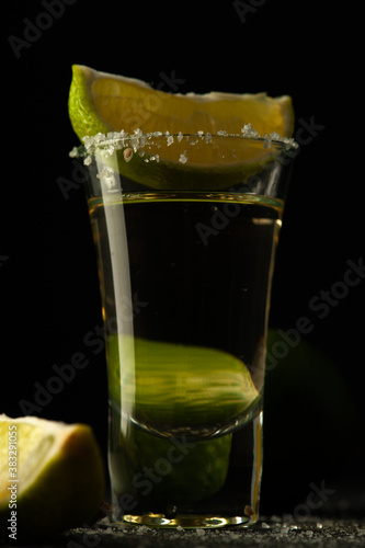 Mexican Tequila Gold in glass with lime slices and salt.