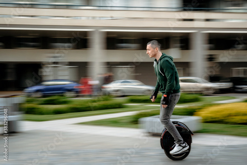 Man riding unicycle on street photo