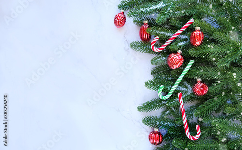 Christmas tree, candy canes, toy decor on marble background. Christmas and New Year holiday background. winter season. copy space