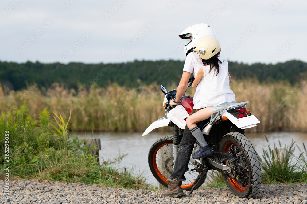オフロードバイクに2人乗りをする父と娘 Stock Photo Adobe Stock