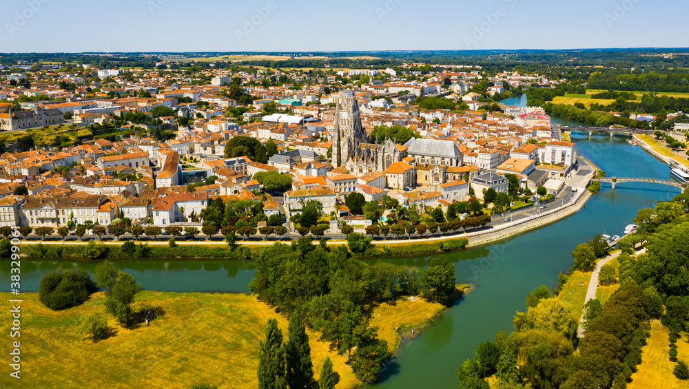 Aerial view of French town of Saintes on banks of Charente river overlooking medieval Roman Catholic cathedral on summer day..