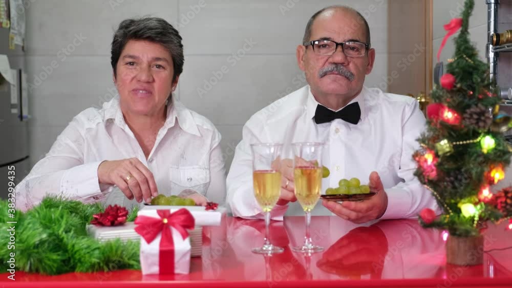 Senior couple celebrating new year eating grapes. Spanish new year tradition. Christmas celebration concept. Senior couple celebrating new year eating grapes. Spanish new year tradition. Christmas celebration concept.