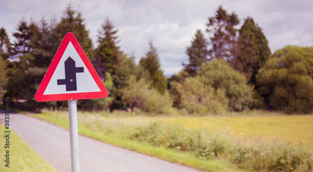 Country road with a priority crossroads sign in rural Scotland Country road with a priority crossroads sign in rural Scotland