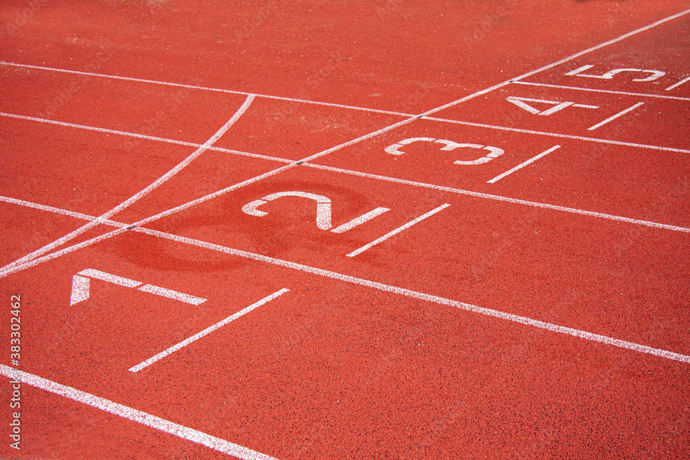 Athletic running track in a stadium with start point positions numbers one two, three, four five. No people.