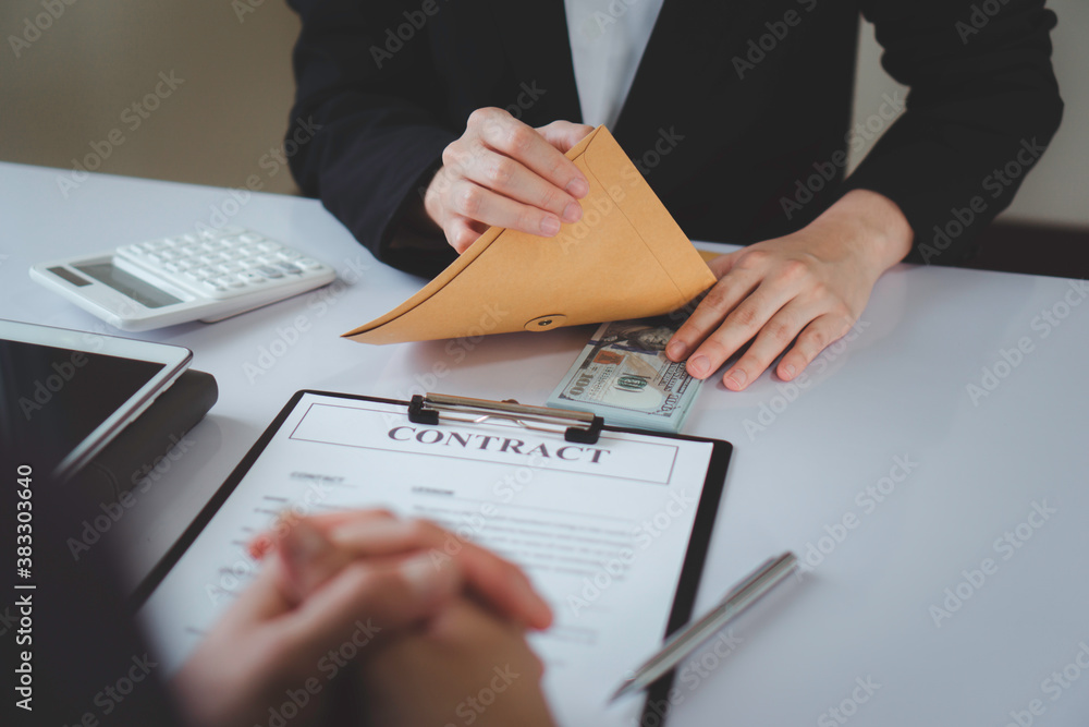 Business woman offering dirty money, cash under prepared envelope to bribe male officer for intercompany contract signing, cash bribery idea. For document signing Business woman offering dirty money, cash under prepared envelope to bribe male officer for intercompany contract signing, cash bribery idea. For document signing
